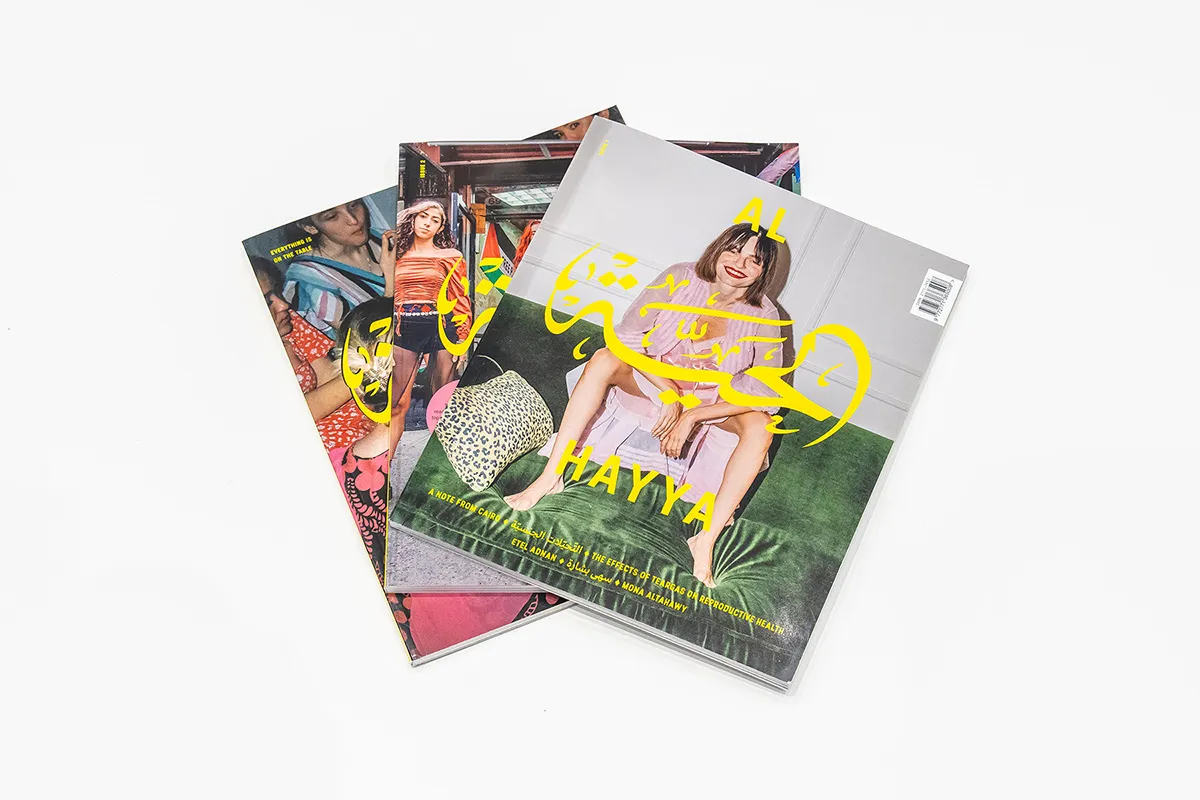 Three magazines with English and Arabic text and photos of Arab women on the covers.