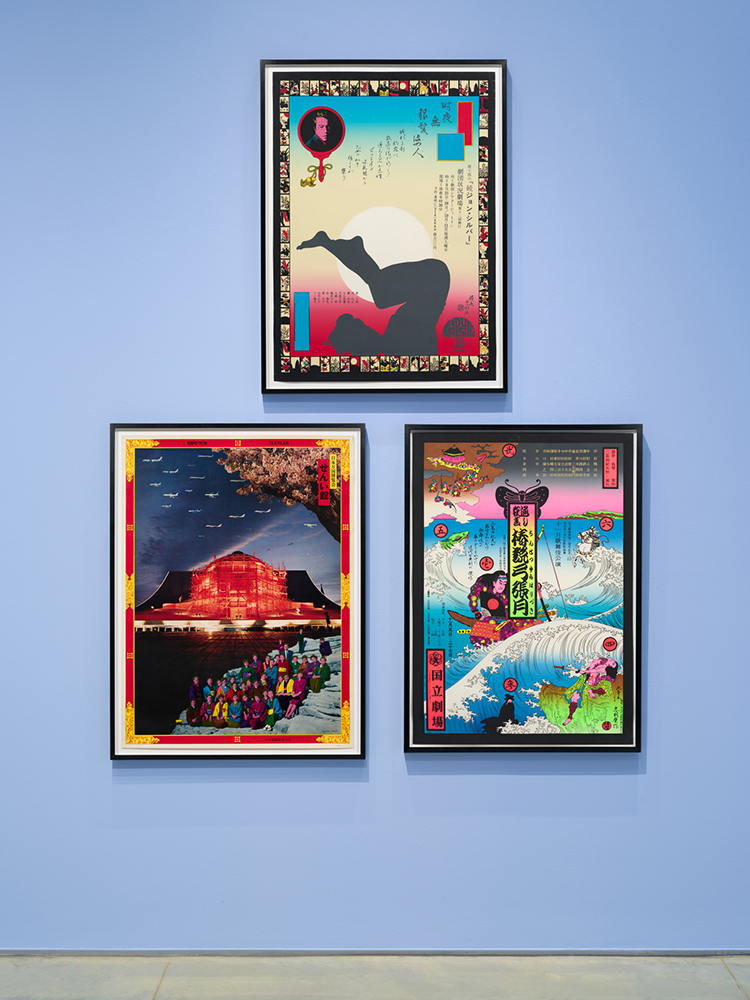 Three framed colorful posters with Japanese text hanging on a light blue gallery wall.