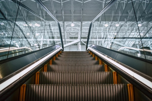 Image of an escalator in a large, well-lit building.
