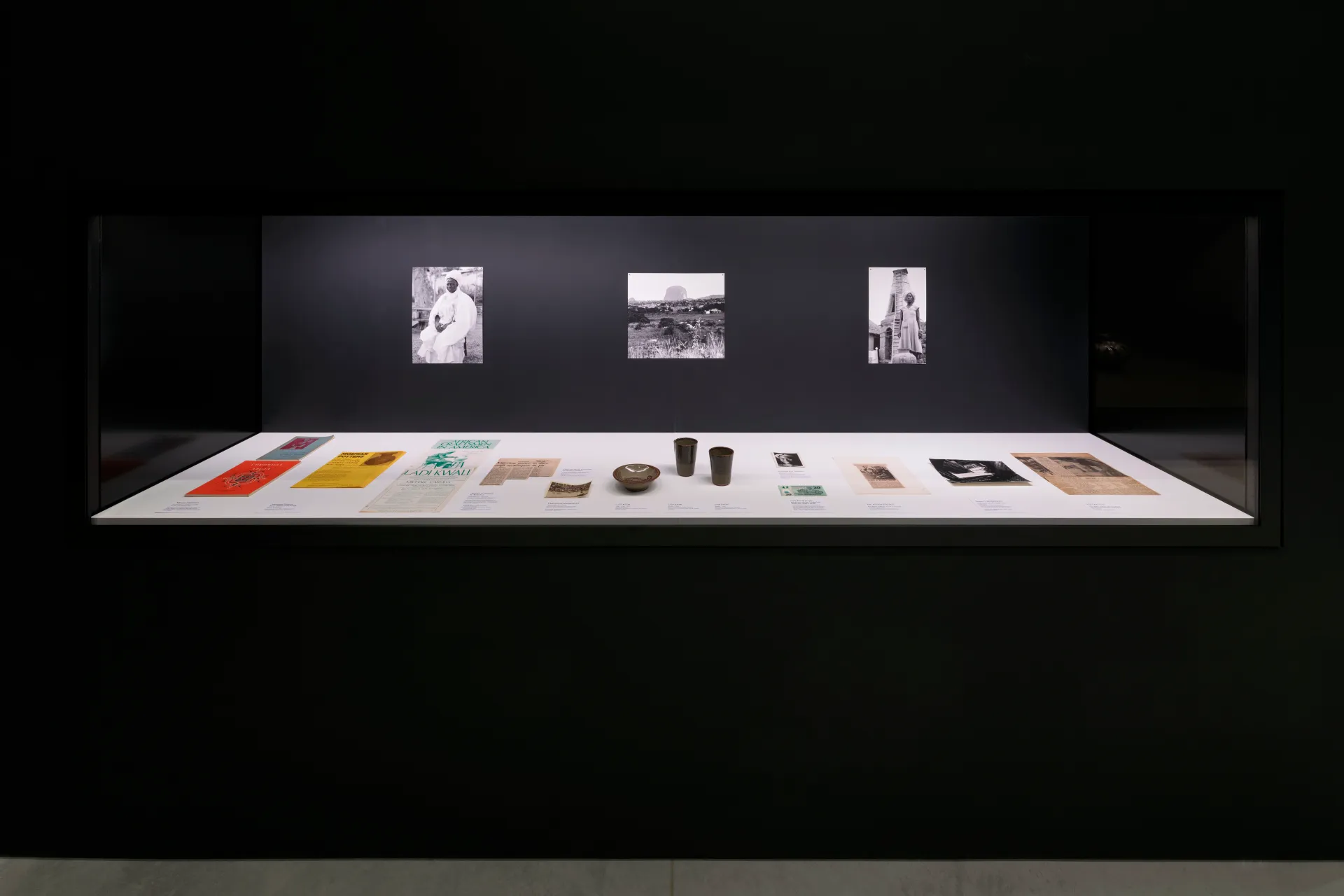 A glass vitrine holding archived publications, ceramic works, newspaper clippings and historic photographic documentation of Ladi Kwali.