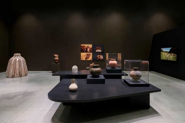 An side-installation view of a gallery exhibition with various clay sculptures and vases, video, and photography.