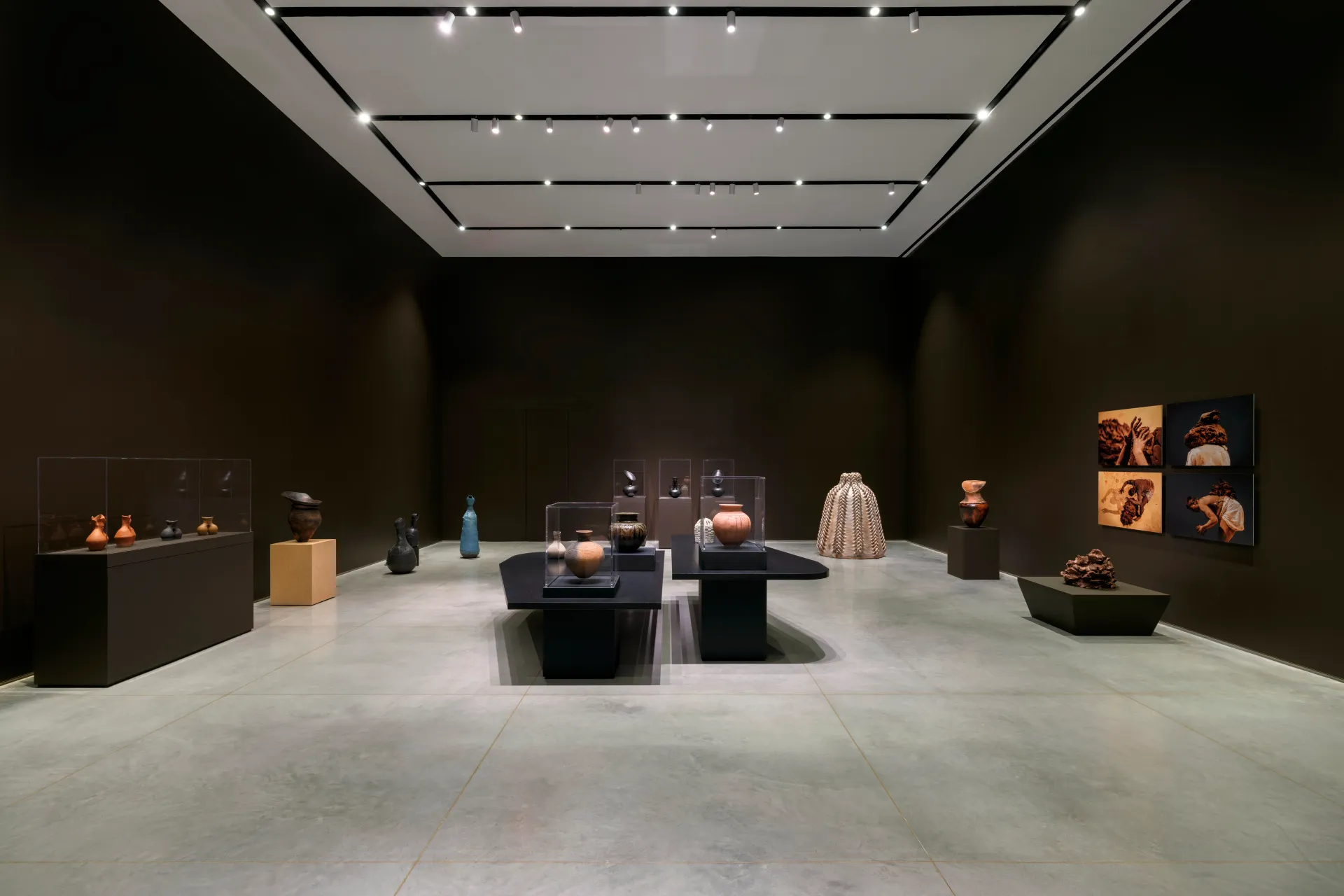 A wide-shot installation view of a gallery exhibition that features artworks relating to clay.