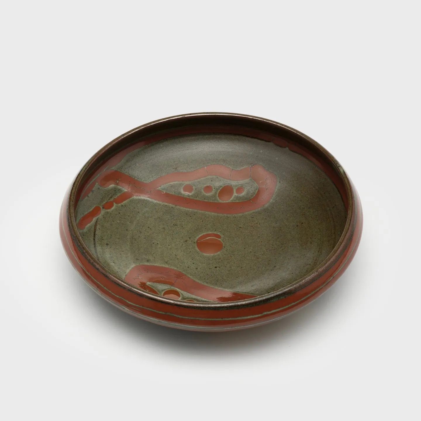 Dish with a raised lip, painted with a looped-ribbon shape motif.