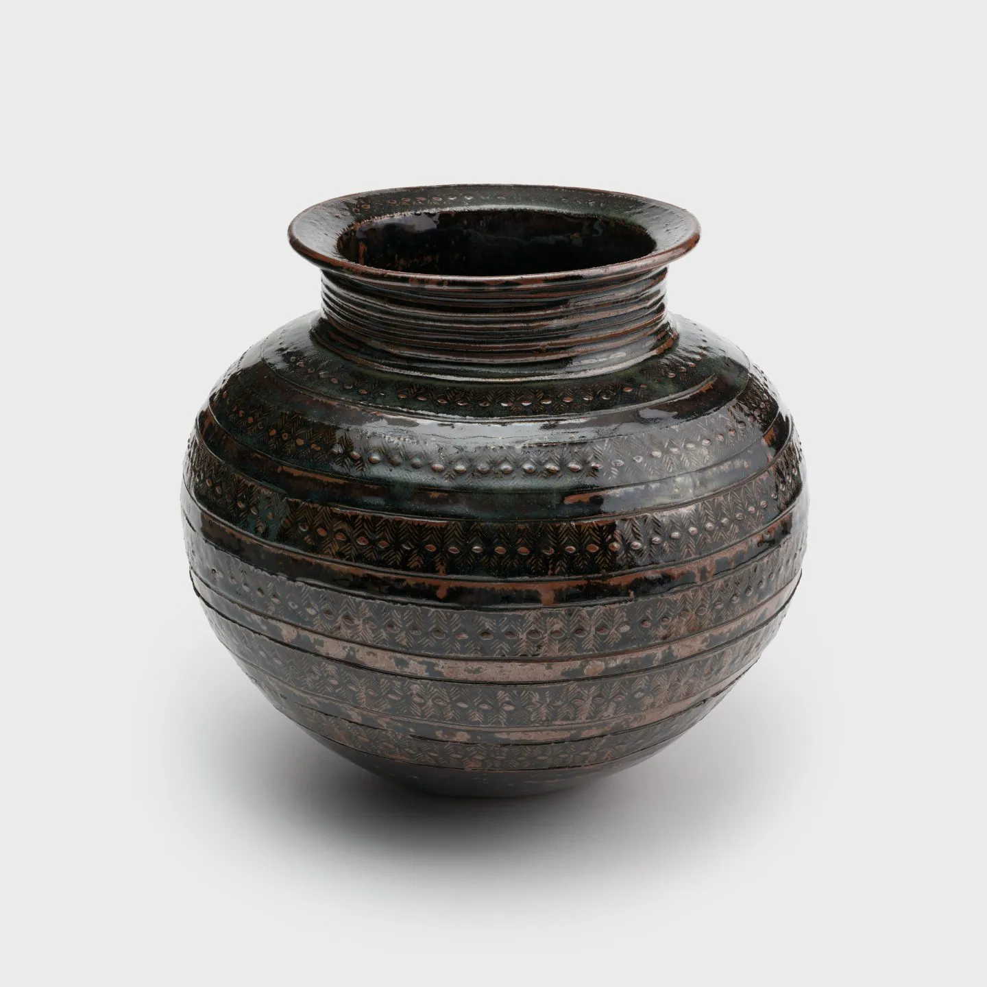 A clay pot with a tapered neck and bands of horizontal stripes decorating the surface.