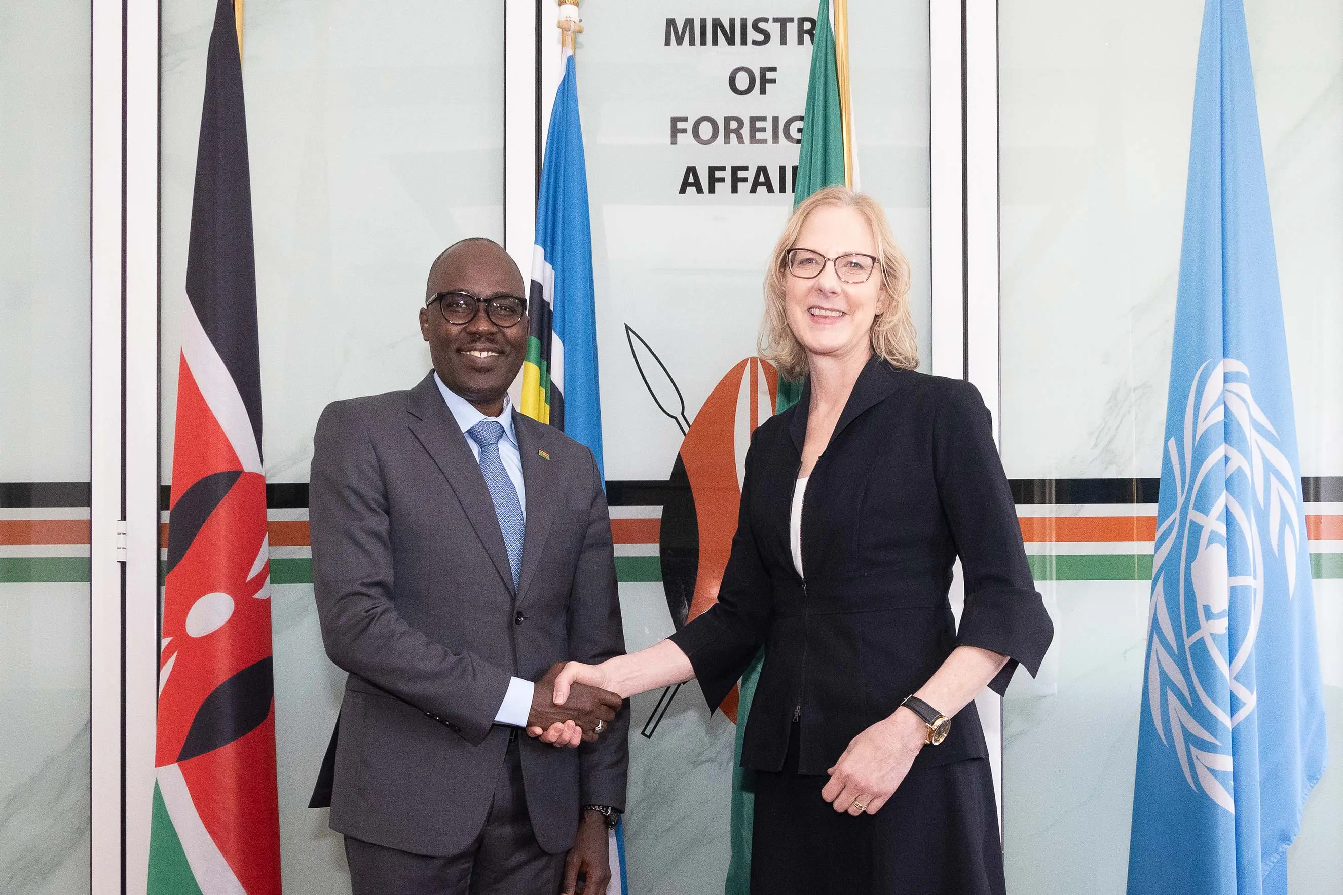A man and woman in professional attire shake hands in front of flags at the Ministry of Foreign Affairs. This image highlights international diplomacy, strategic partnerships, and global leadership during a high-level official visit.