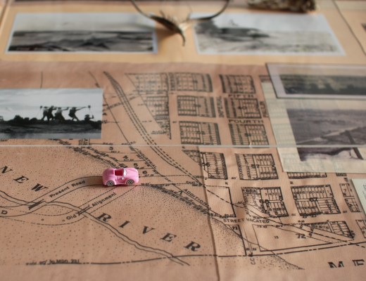 A tiny pink toy-car on top of historical maps, collaged with archival photos of people working on a river.