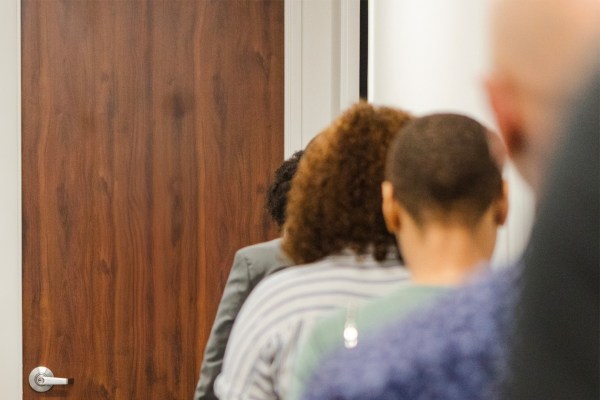A line of people waiting to enter a room, viewed from behind. This image represents voter participation, civic engagement, and democratic access, illustrating the Ford Foundation's commitment to strengthening democracy through new funding for inclusive representation and social justice initiatives.