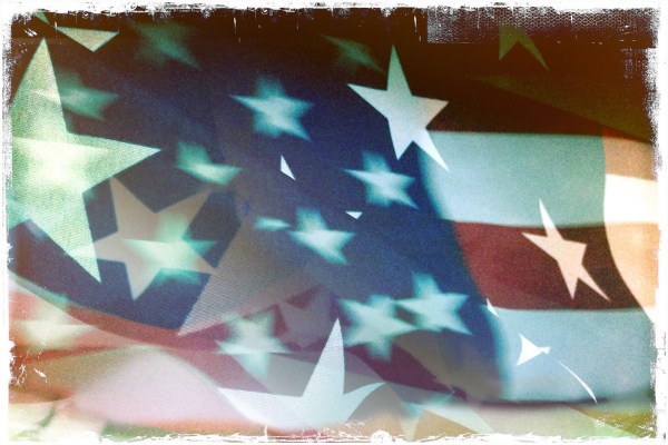 An abstract, stylized graphic of a waving American flag with layered, floating white stars and translucent red and blue stripes. The image features a distressed, vintage-style white border, representing themes of democracy and American patriotism.